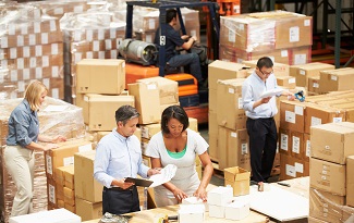 Male And Female Workers In Warehouse Preparing Goods For Dispatch
